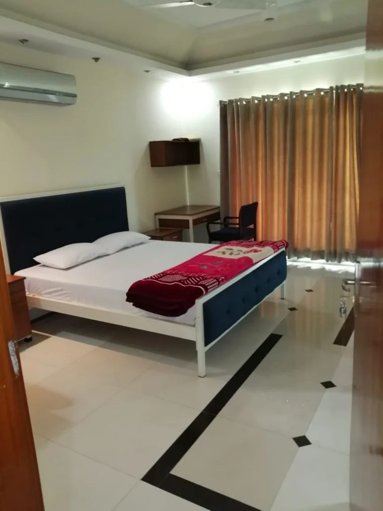 CEMB Guest House bedroom with king size bed and study table