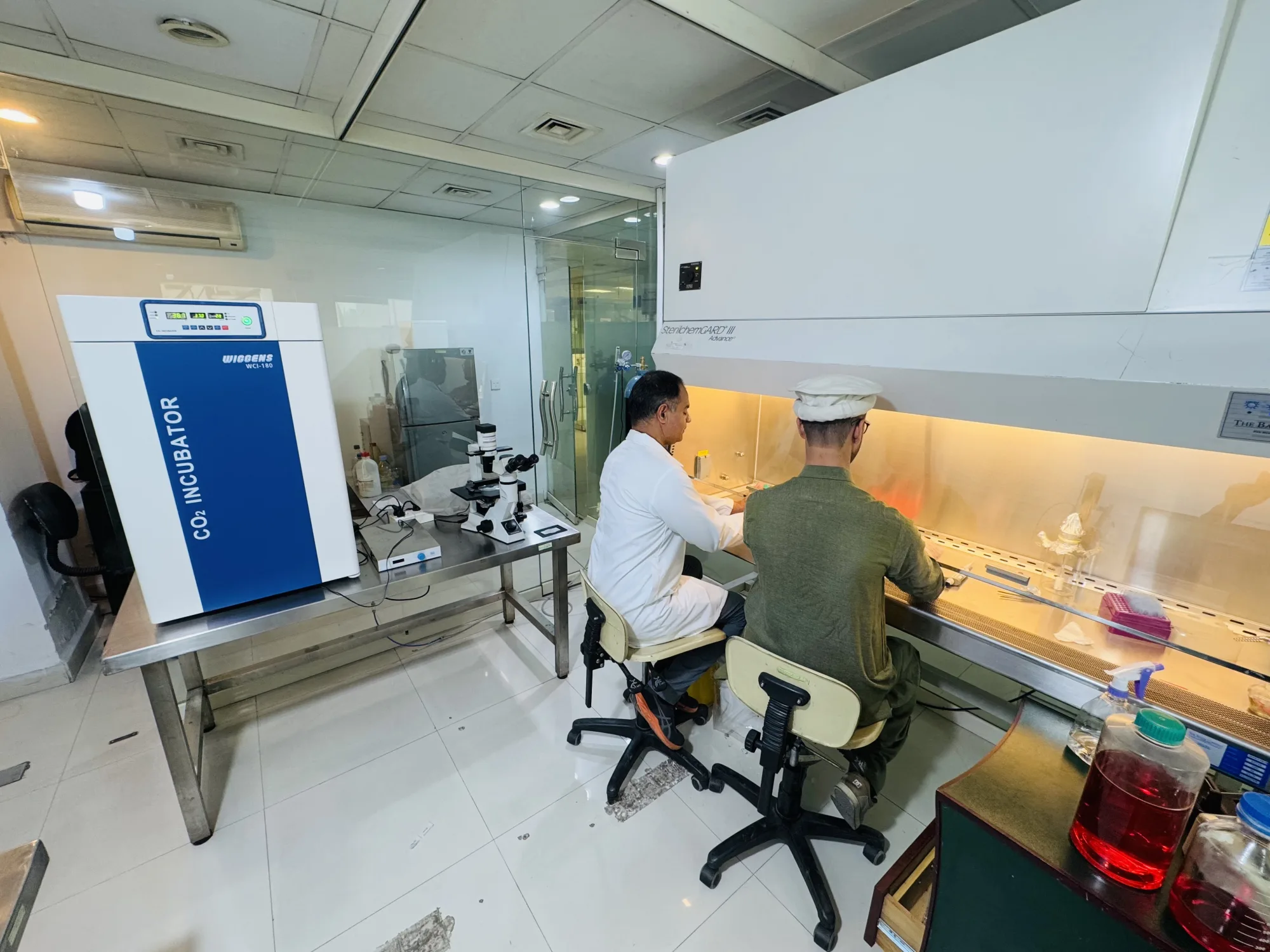 CEMB researchers working at a biosafety cabinet in the diagnostics laboratory